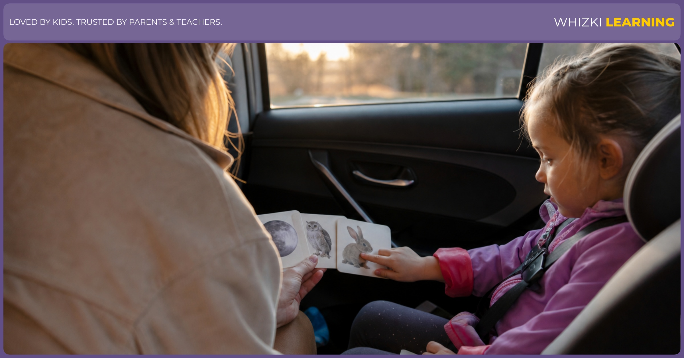 A caregiver and child play a rhyming listening game with picture cards inside a parked car.