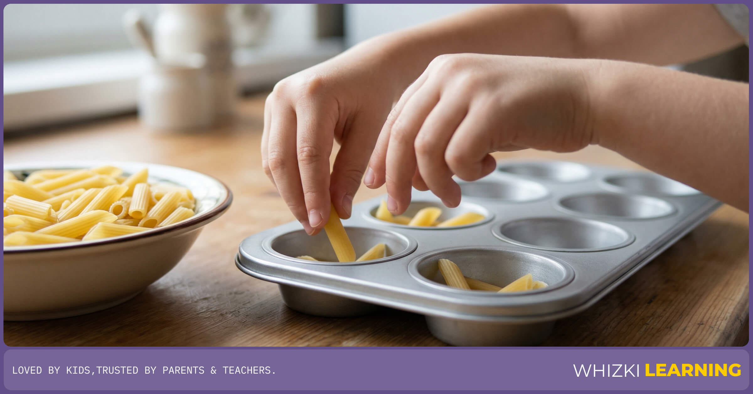 A young child's hands sorting and counting dry macaroni noodles into the cups of a silver baking pan.