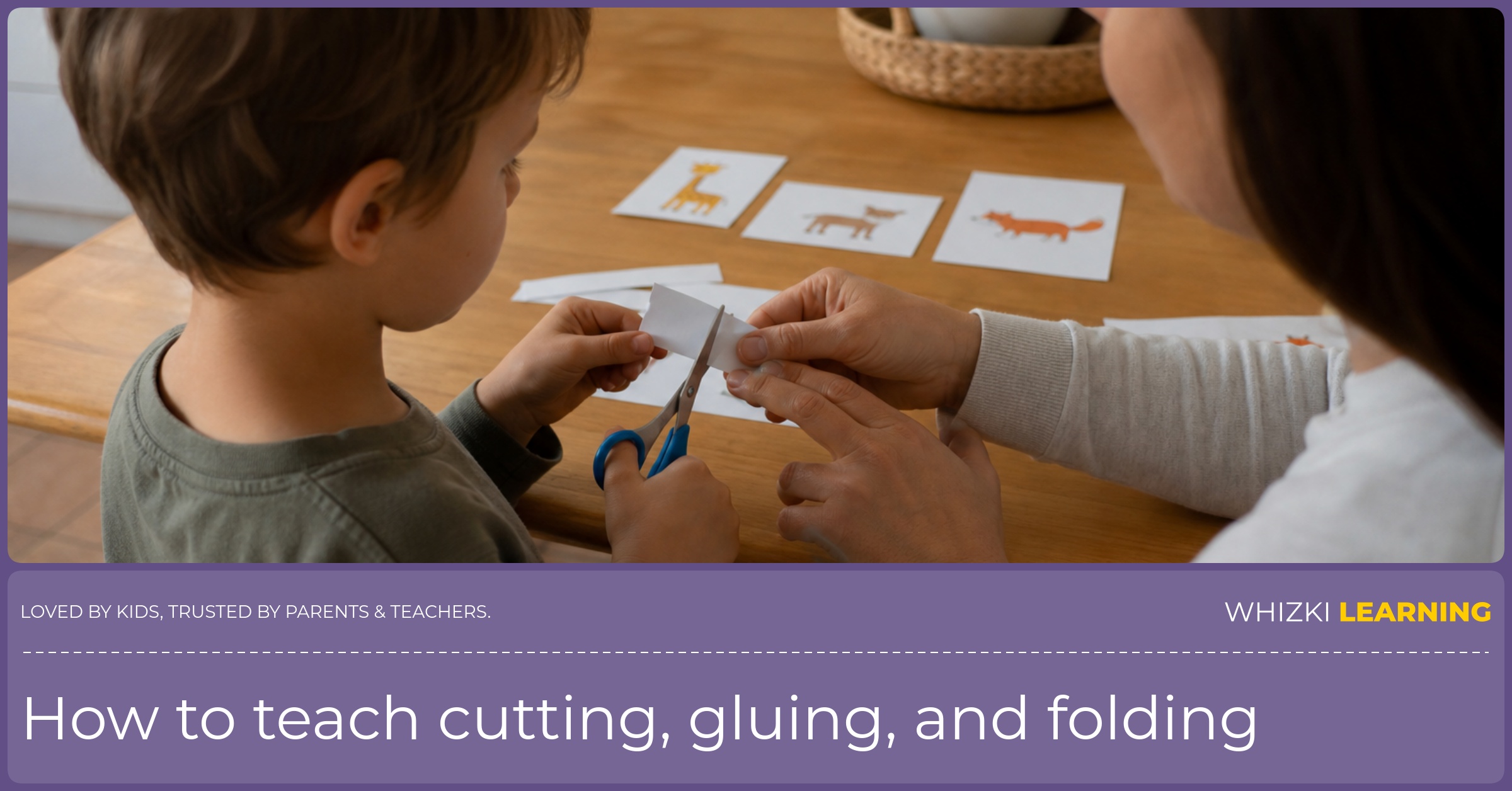 A parent sits beside a young child who is cutting a short paper strip with child-safe scissors at the kitchen table.