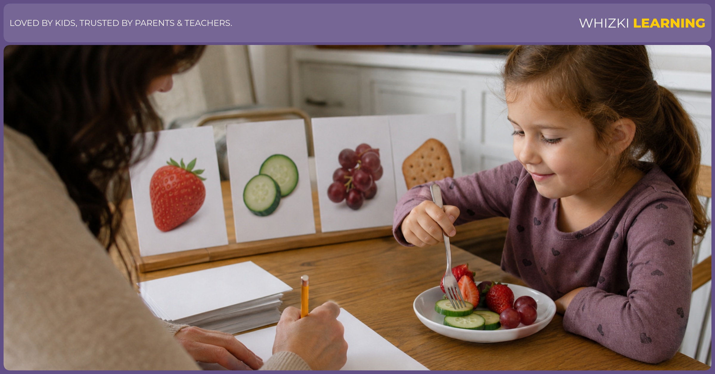 A caregiver writes snack observation words while a child gently explores food texture with a fork.