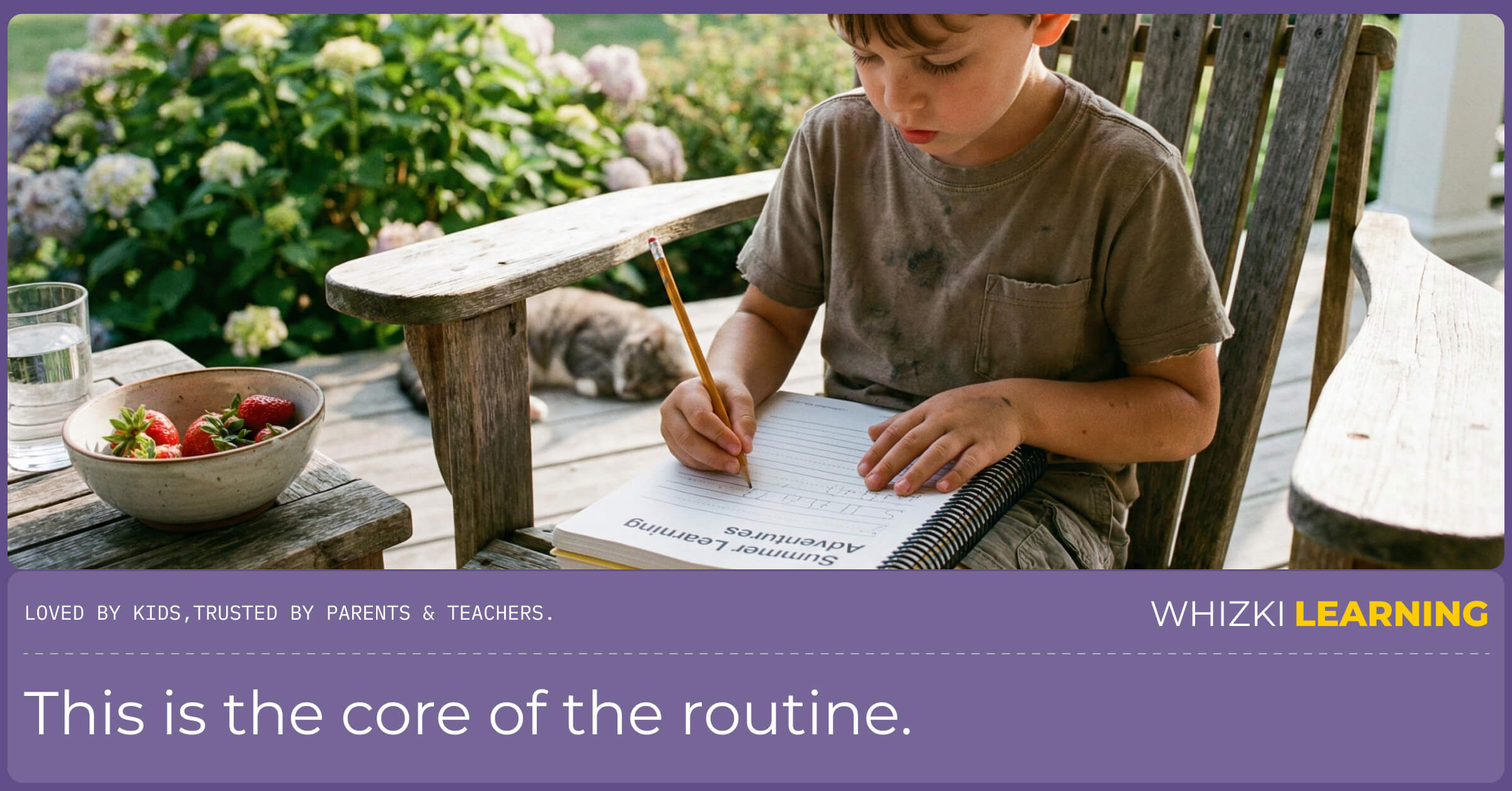 A young child in summer clothes sitting at a small table outside, happily working in a printed workbook.