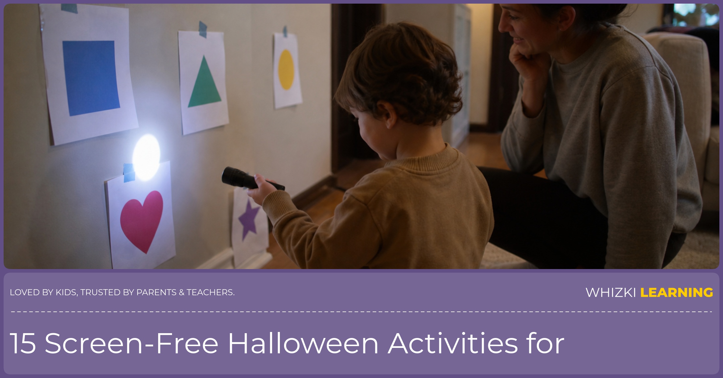A parent sits beside a young child using a flashlight to find paper shapes on the living room wall.
