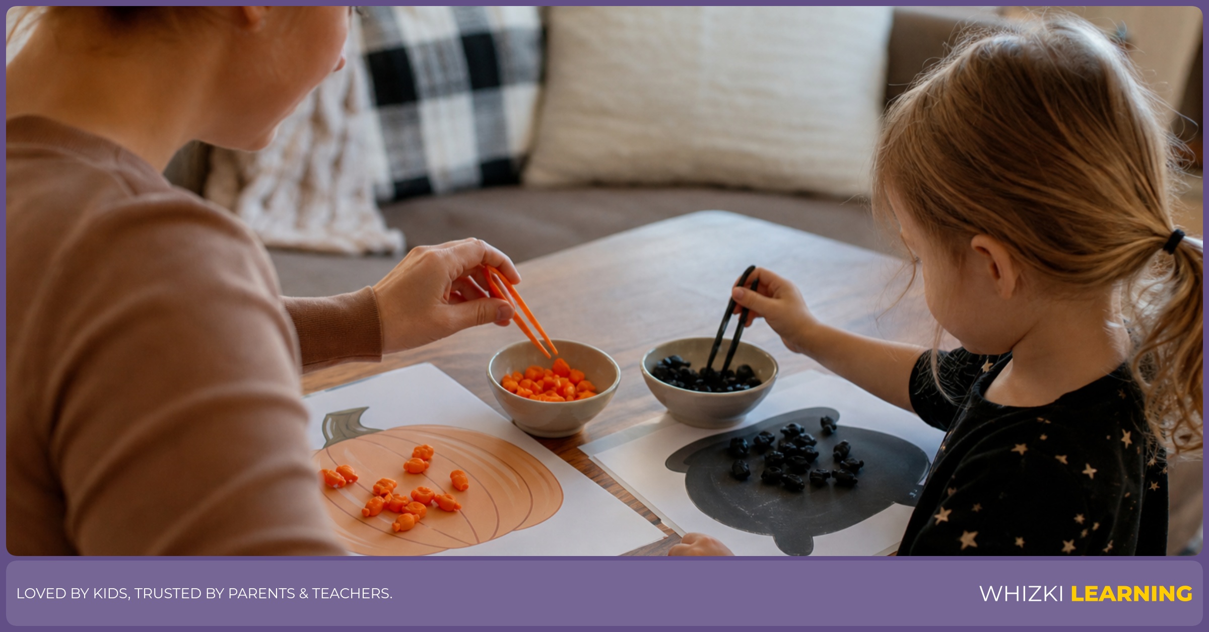 A child uses tweezers to move small orange and black pieces into bowls while an adult watches nearby.