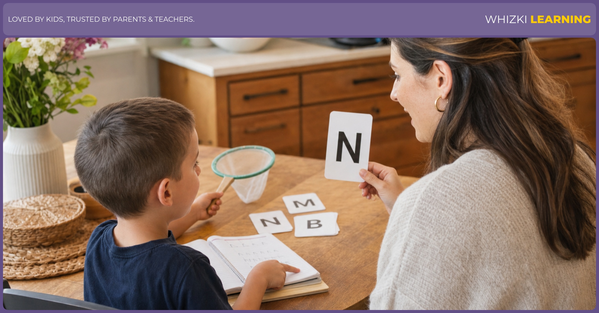 A parent and child sit at a kitchen table with a small net and notebook, the child’s fingers pointing while the parent models the word for letter N. Warm natural light, calm focus, screen-free.
