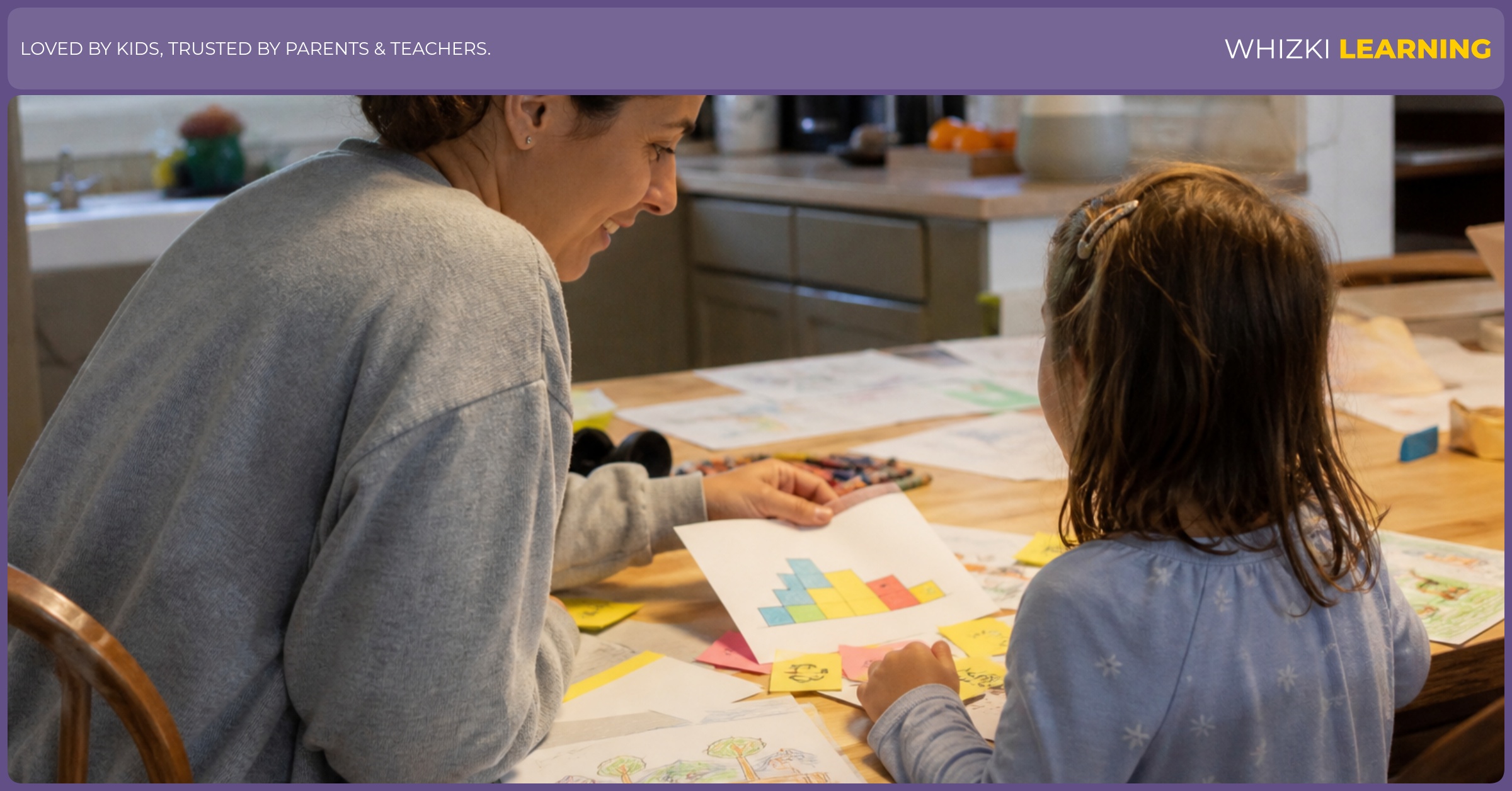 A caregiver and child look at drawings and block designs together on a kitchen table.