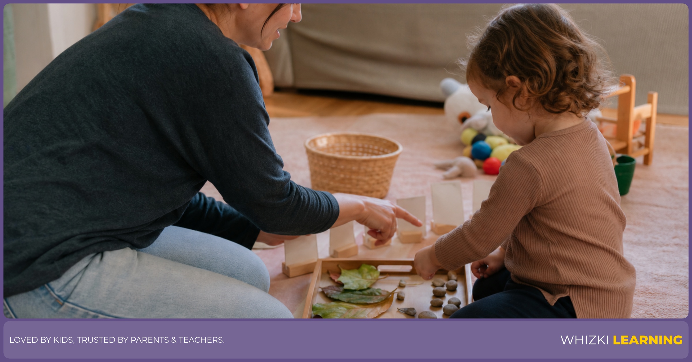 A caregiver and child sort leaves, small stones, and craft sticks on a tray during hands-on learning at home.