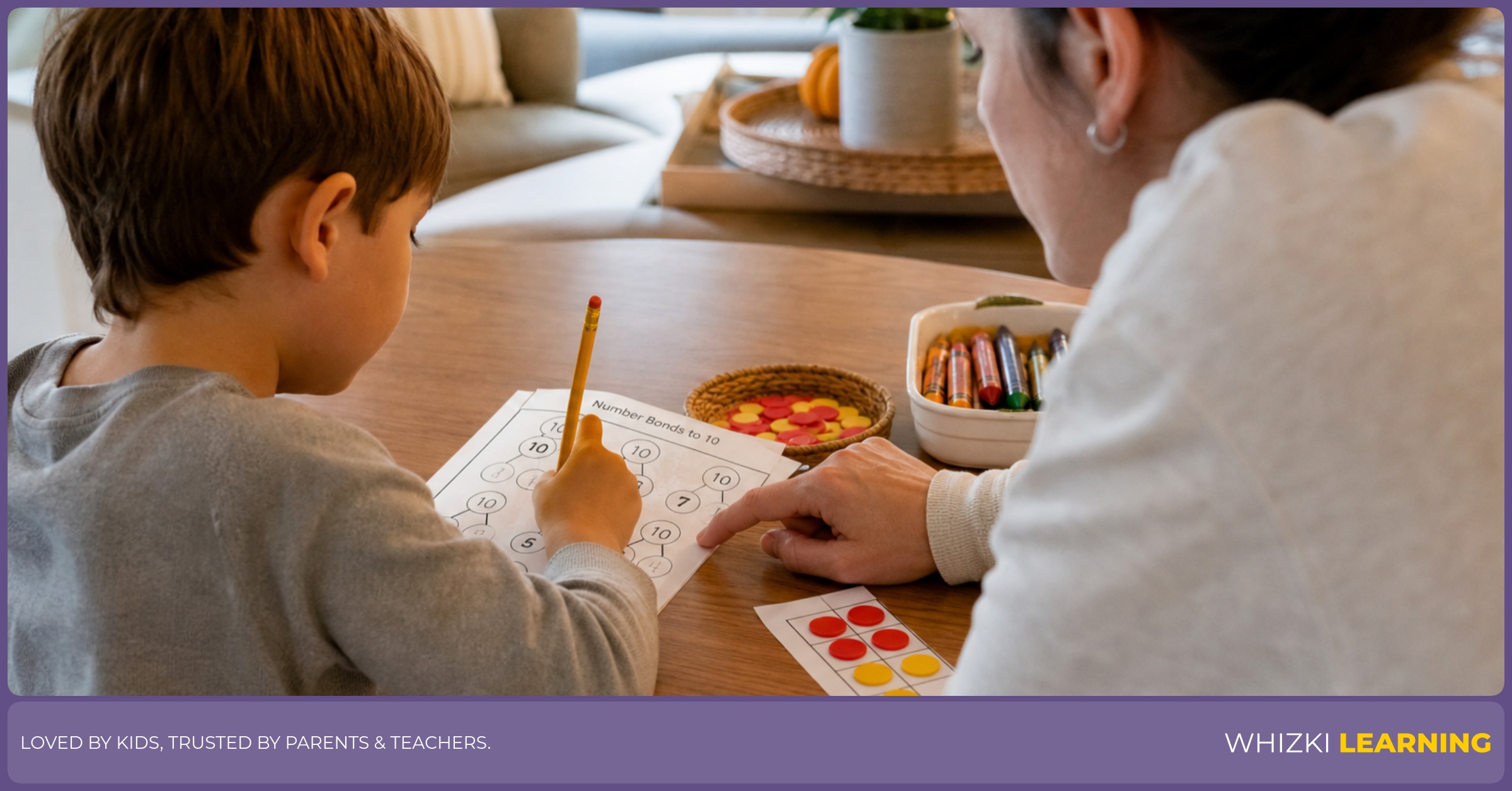 A caregiver helps a child complete a number bonds to 10 worksheet with counters and crayons on the table.