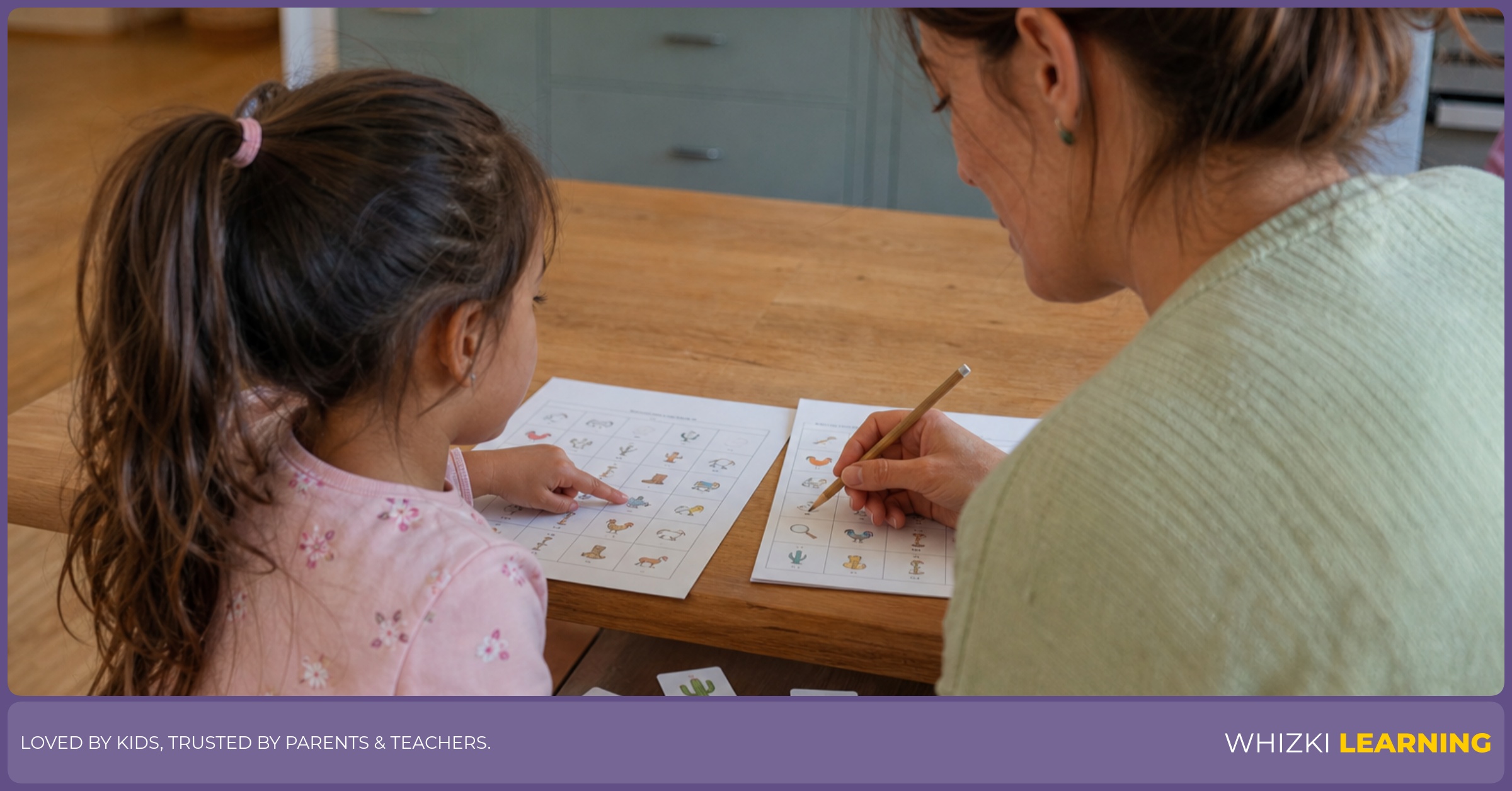 A parent and child compare repeated picture icons on printed worksheets at a kitchen table.