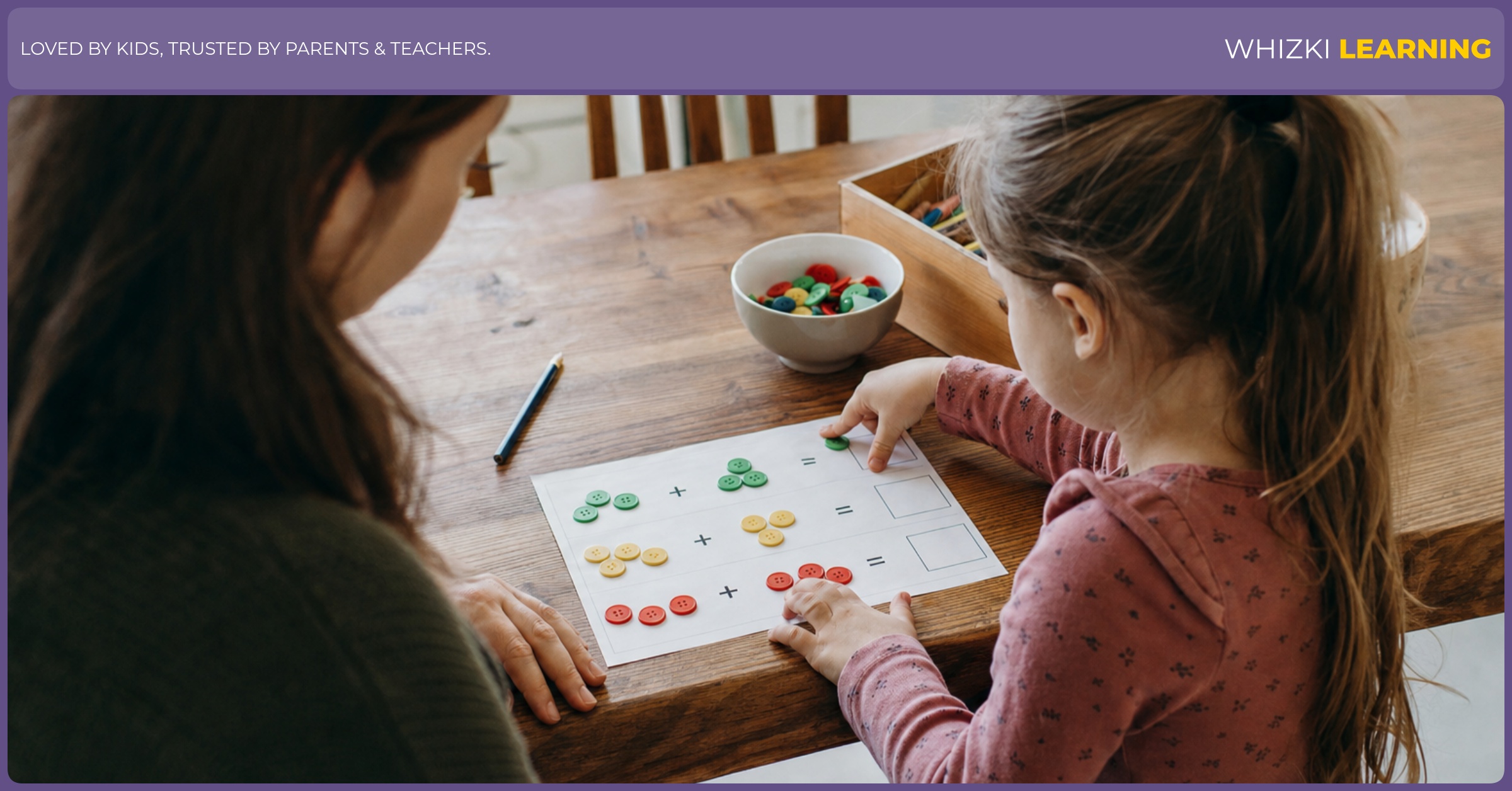 A parent sits beside a young child who counts small objects on a picture addition worksheet at the kitchen table.