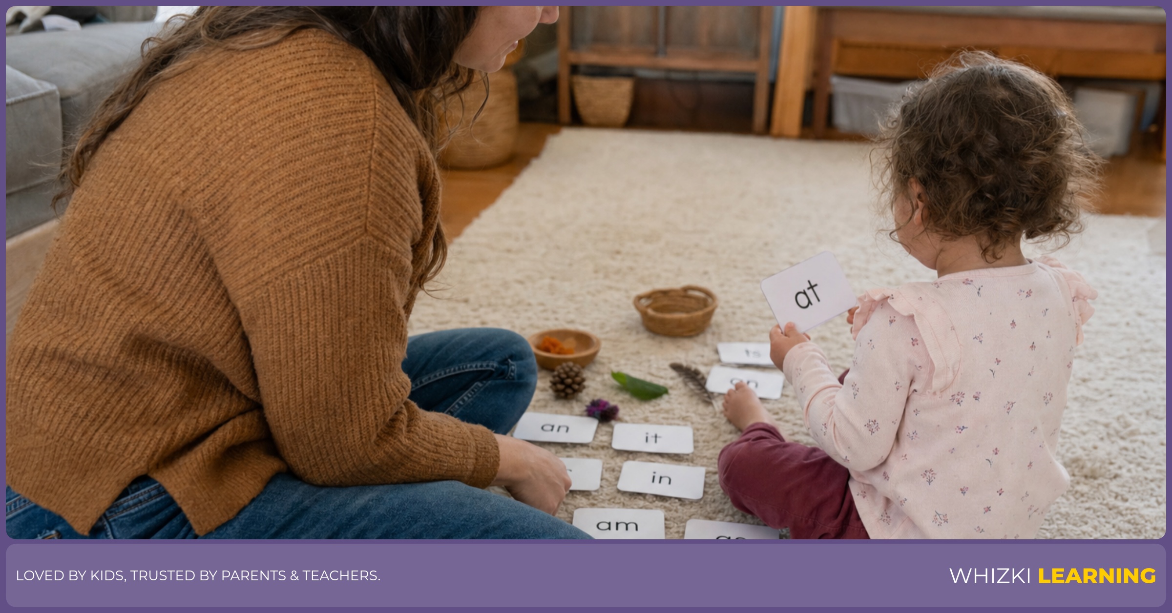 A caregiver and young child sort sight-word flashcards with small household objects on a living-room floor.