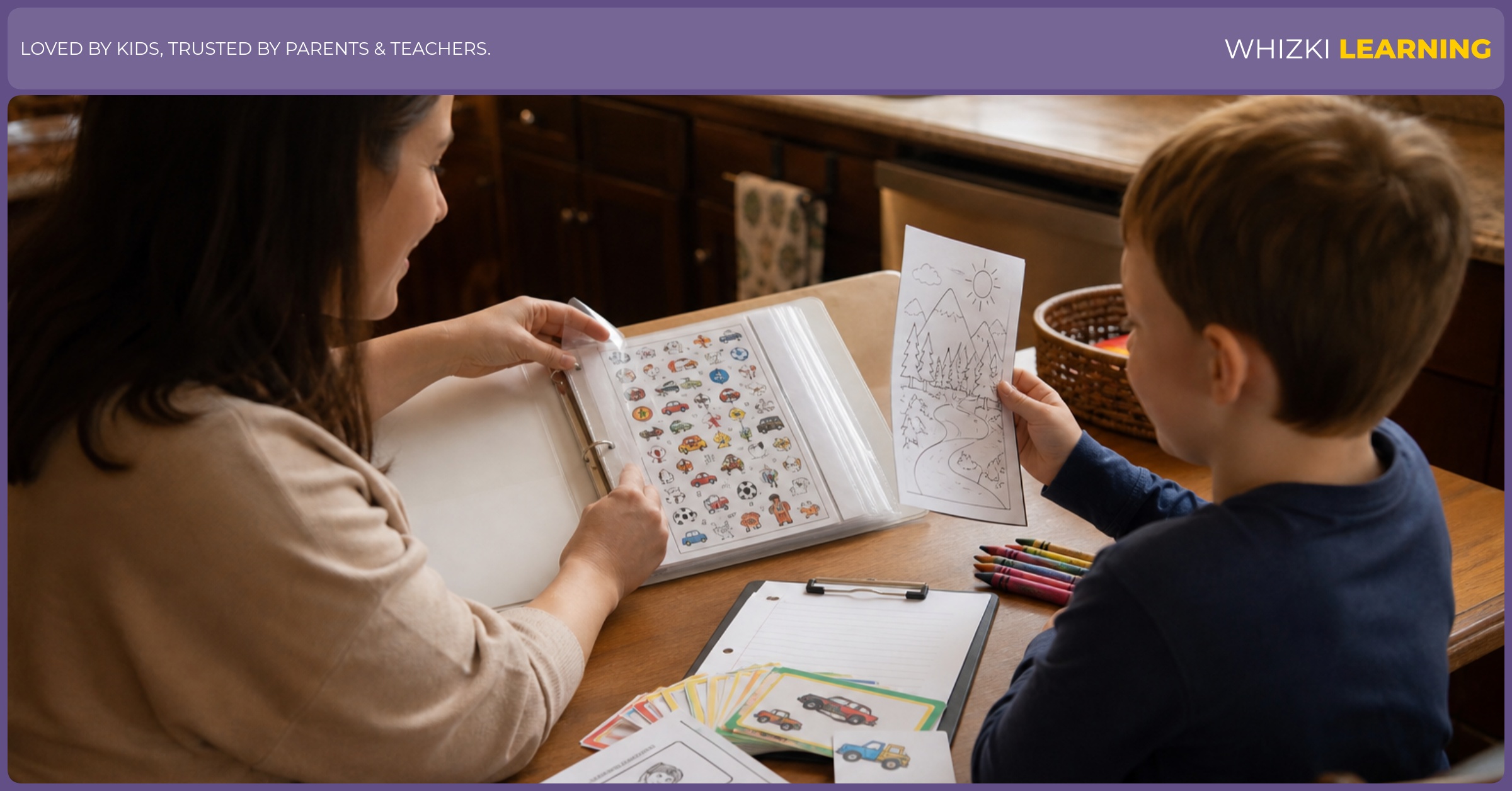 A parent and child arrange printable road trip pages, crayons, and a clipboard inside a binder at the kitchen table.
