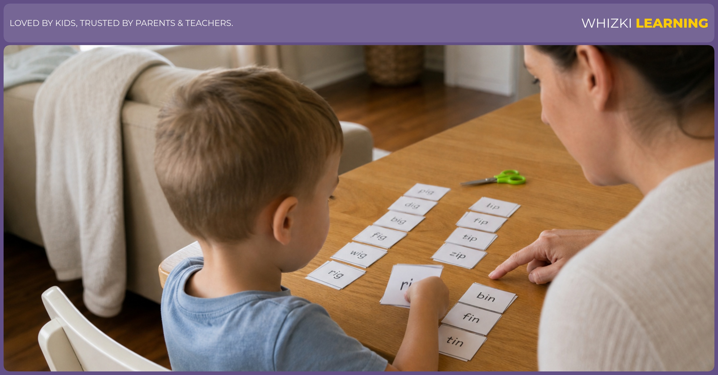 A parent helps a young child sort short I word family cards at a kitchen table.