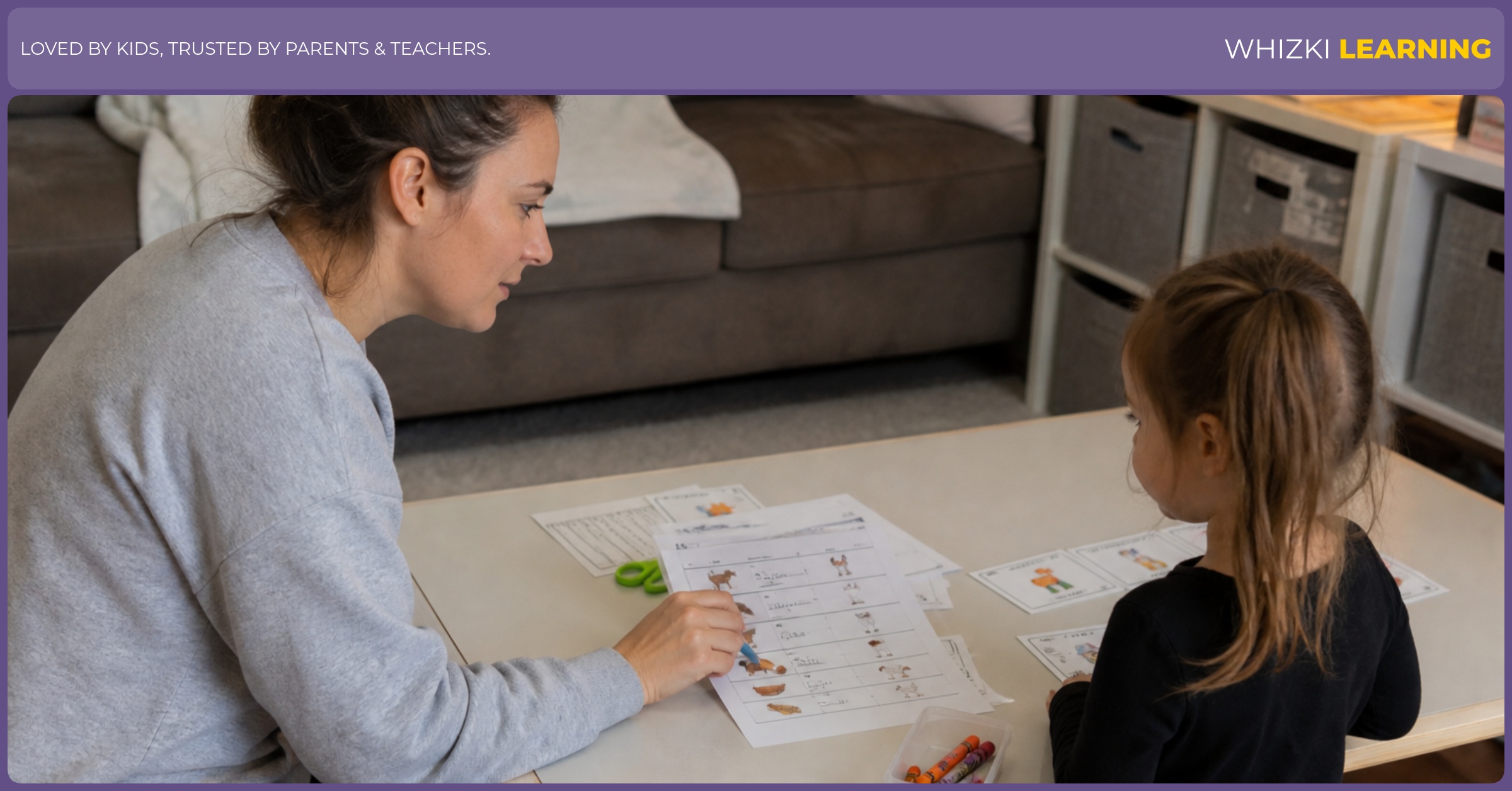A teacher reviews a printed worksheet pack with a pencil while checking picture variety across pages.