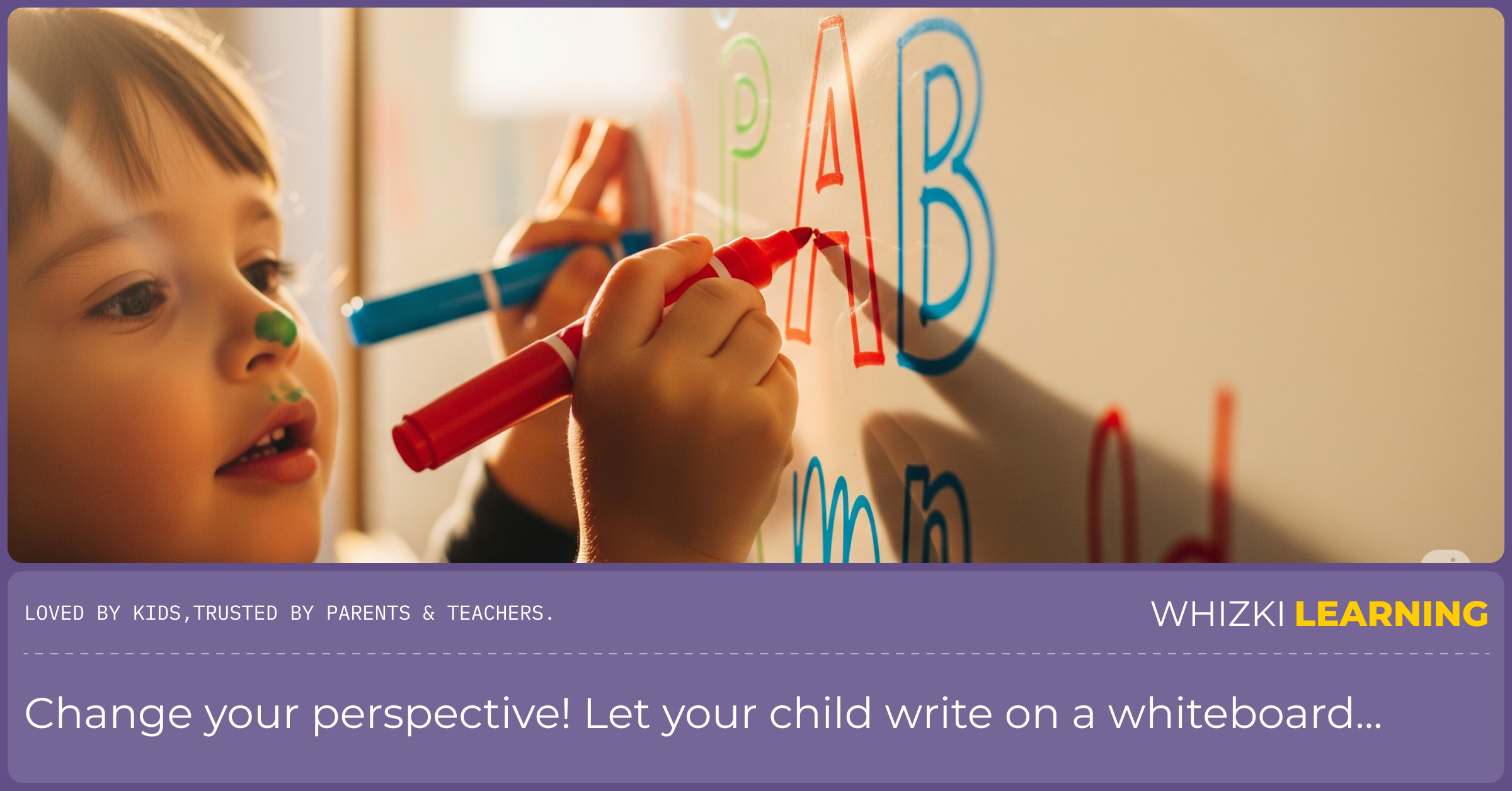 A young boy smiling as he draws letters on a large, wall-mounted whiteboard with colorful markers.