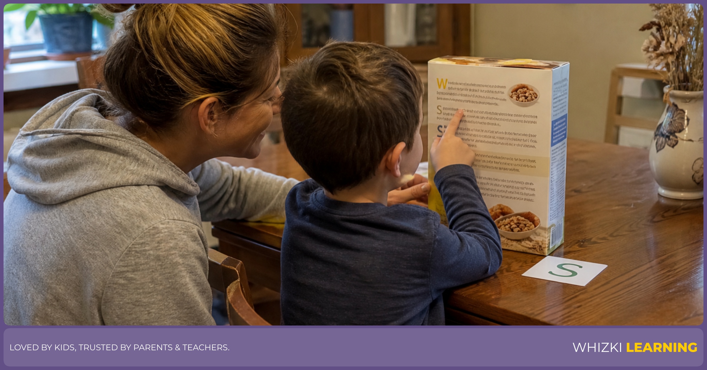 A parent and child search for matching letters on cereal boxes at a kitchen table.