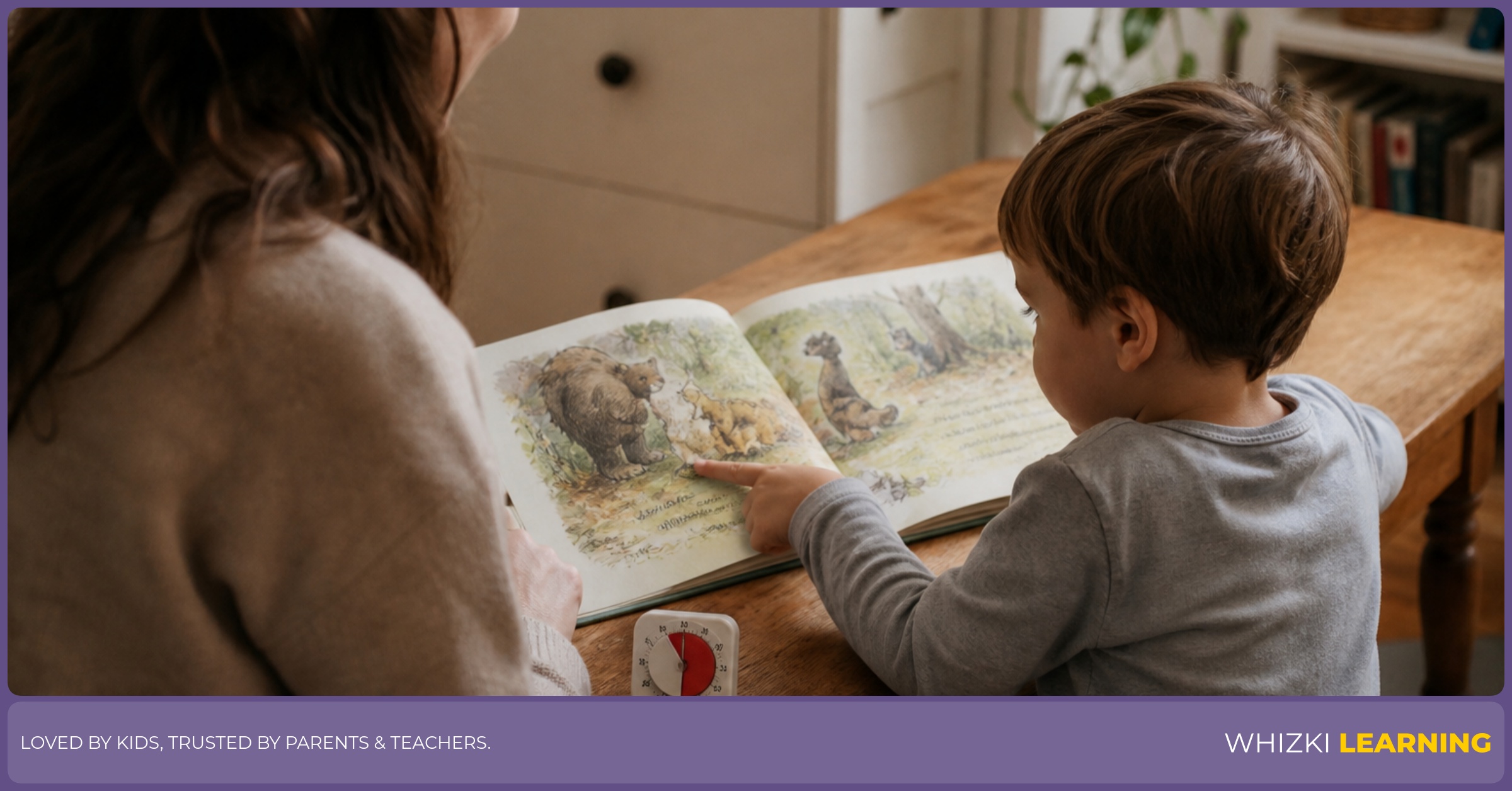 A parent and child sit at a kitchen table with one familiar picture book open while the child points to a page.